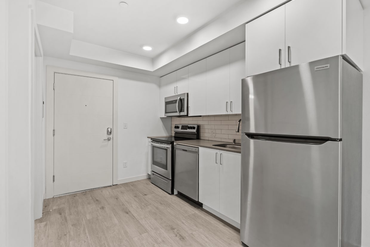 Modern kitchen with stainless steel appliances and sleek contemporary finishes. - Studio Standard w/Patio