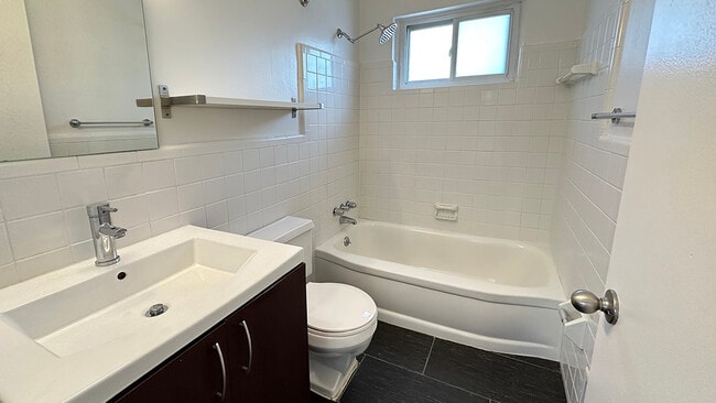 Subway tile bath surround, black tile flooring, farmer&#39;s sink, nickel hardware, rainfall showerhead and a window, too. - Metropolitan 13 Flats