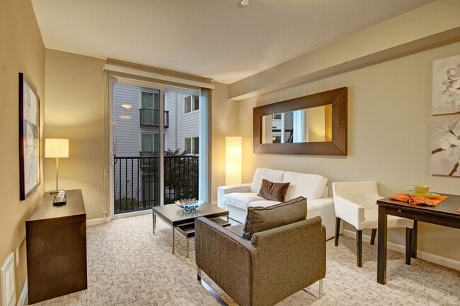 A cozy living area with large sliding glass doors leading out to the Juliet balcony - The Artiste