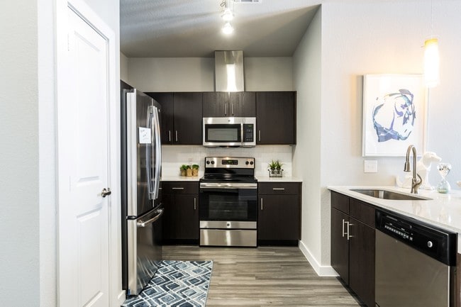 Kitchen with island, farm-style sink, wood-plank flooring, and pantry - Urban North
