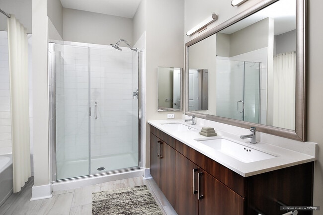 Signature Collection bath with oak cabinetry, white quartz countertops, and hard surface flooring - Avalon Rockville Centre