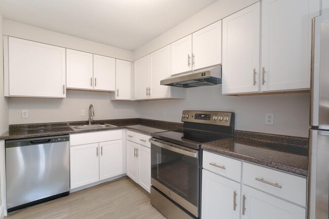 Modern kitchen style with updated white cabinetry and sleek stainless-steel appliances, creating a fresh, clean look. - Stone Run East