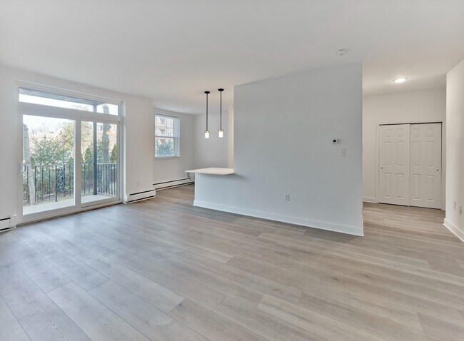 Open living and dining area with natural light and balcony access at Crestwood Apartments in Wayne, PA - Crestwood