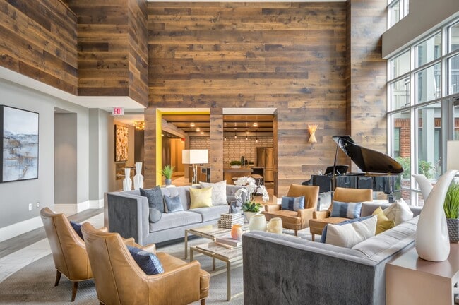 Inviting resident lounge with plush seating, a grand piano, and a warm, modern vibe. - The Heights at Goose Creek Village
