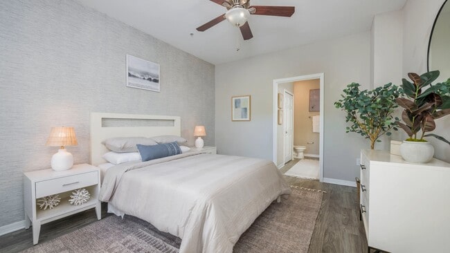 Step into your opulent haven, the spacious master bedroom. With wood-style flooring underfoot and a ceiling fan that dances to your mood, it's fit for royalty. Plus, enjoy the luxury of an ensuite bathroom and roomy walk-in closets – your kingdom awaits! - Banyan Bay