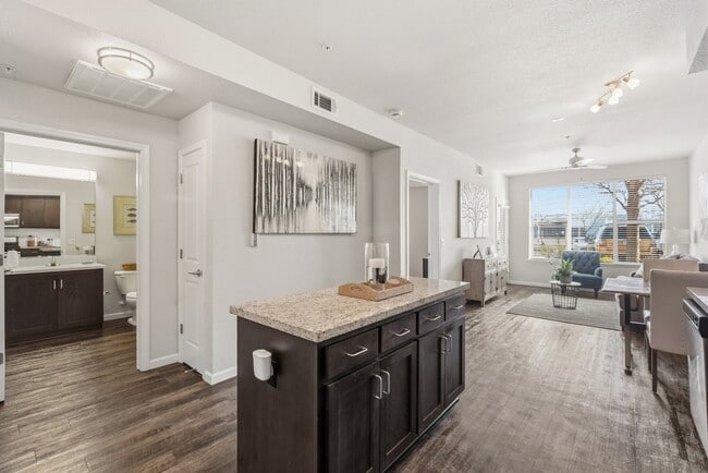 Aspire Apartments Tracy California A modern kitchen with dark wood cabinets and a granite countertop. - Aspire Apartments