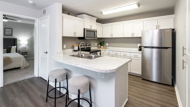 Indulge open living in this stunning kitchen oasis boasting ample cabinetry and a versatile breakfast bar overlooking the living area for the ultimate in convenience and style. - Market 1900 Apartment Homes