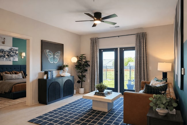 Bright, spacious living area with abundant natural light and a sleek ceiling fan with integrated lighting. - Cypress Point