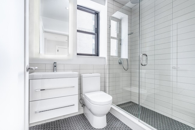 Bright tiled bathrooms with large backlit designer mirror, Hans Grohe chrome fixtures and Villeroy & Boch vanity - The Century