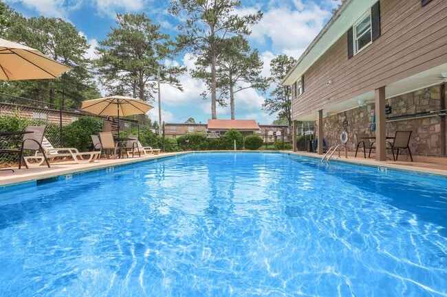 Relax in the inviting pool at Guest House, surrounded by lush landscapes and sunshine. Enjoy the perfect blend of comfort and community. Schedule a tour today and see why this is the ideal place to call home! - Guest House