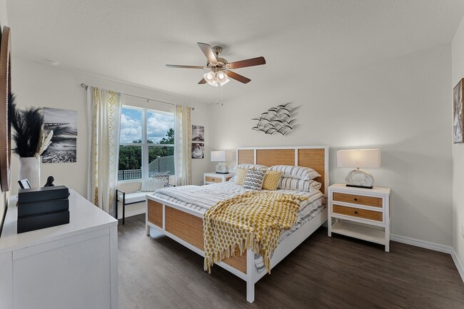 Bright and spacious primary bedroom with large window and modern ceiling fan. - Cedar Ridge