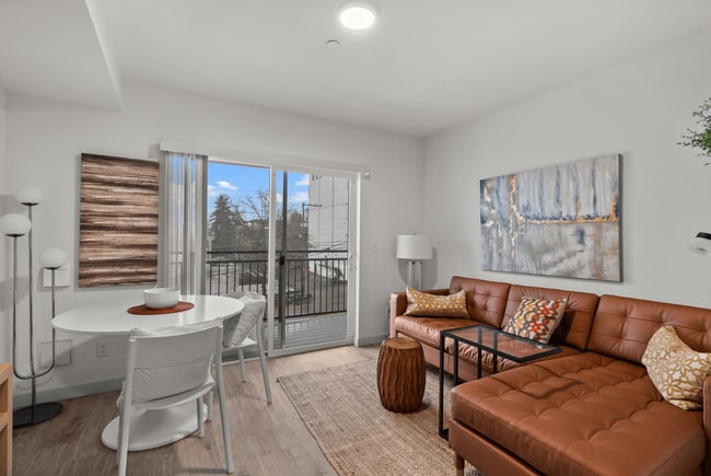 Bright living and dining area with access to a private balcony. - The Ruby Apartments