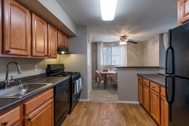 Designer Kitchens With, Wood Flooring, Sleek Black Appliances & Solid Wood Cabinets - The Brook At Columbia