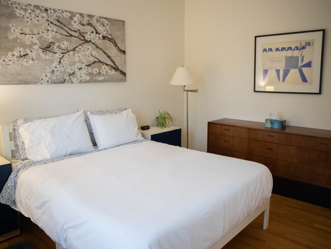 Master Bedroom with Queen bed, dresser, two nightstands, two lamps, and two closets. - Lake Street Penthouse
