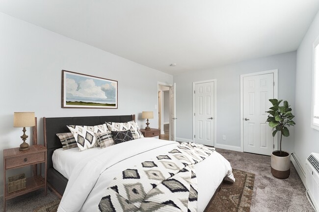 Step into comfort at Mid Island Apartments. This spacious bedroom features modern decor, ample storage, and a serene atmosphere, perfect for relaxation. Elevate your living experience—schedule your visit today! - Mid Island Apartments