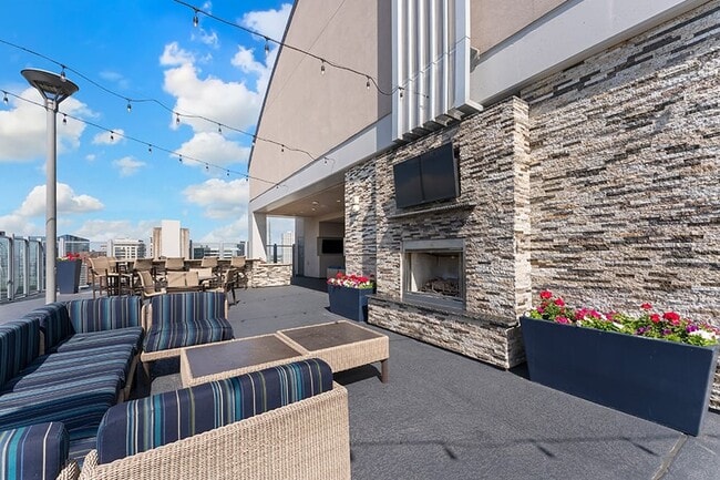 SkyDeck seating and fireplace with stunning city views - SkyHouse Dallas Apartments