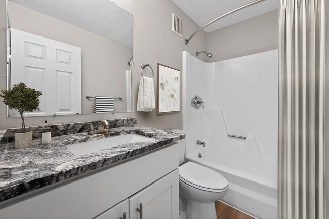 Elevate your daily routine in the stylish bathroom at Eagle Rock Apartments at Hudson, featuring modern finishes and ample space. Enjoy the perfect blend of comfort and functionality. Schedule your personal tour today and see it for yourself! - Eagle Rock Apartments at Hudson