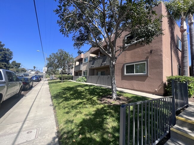 Sidewalk view of apartment buildings at Villa Pacific Apartments in Oceanside, California. - Villa Pacific Apartments