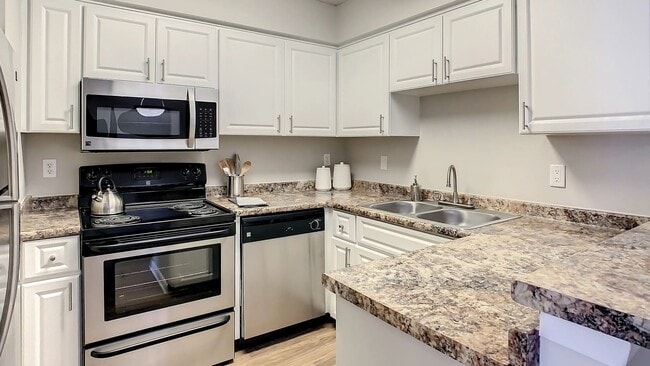 Immerse yourself in your dream kitchen with modern white cabinetry, granite-inspired countertops, and sleek stainless-steel appliances. - Adele Place