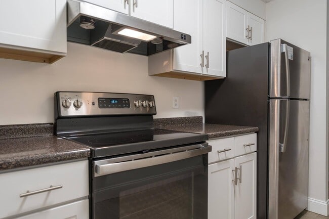 Modern kitchen style with updated white cabinetry and sleek stainless-steel appliances, creating a fresh, clean look. - Stone Run East