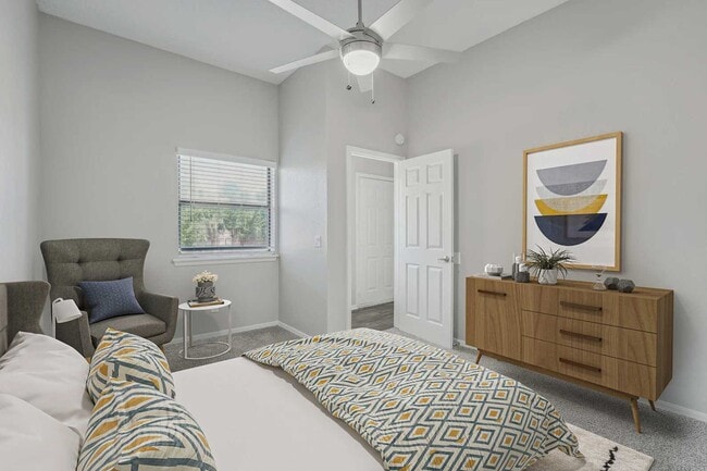 Bedroom with ceiling fan, patterned bedding, gray accent chair, wood dresser, framed wall art, and carpet flooring - Walnut Creek