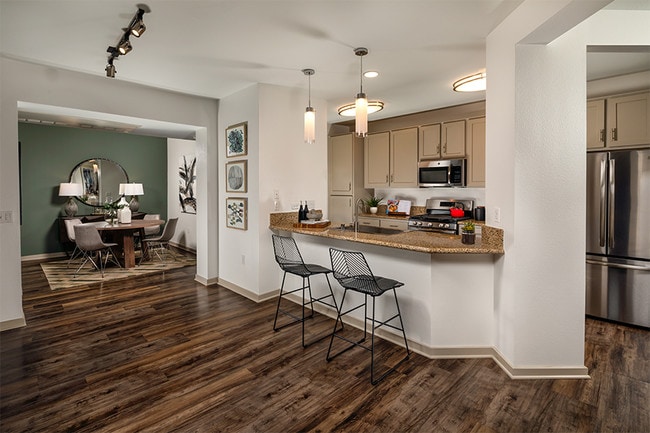 Kitchens with luxury vinyl plank flooring, gas ranges, shaker-style cabinets and stainless steel appliances - Mira Bella Apartments