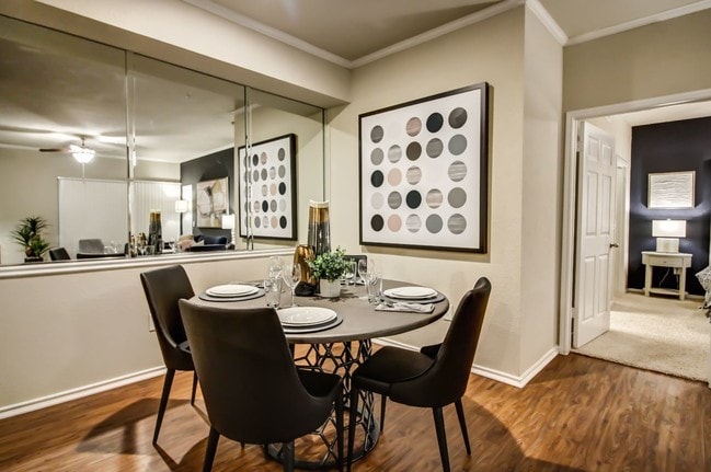 Cozy dining nook with hardwood style flooring, crown molding and wall mirror - Colonnade at Willow Bend