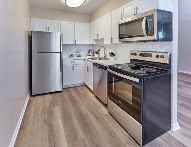 Contemporary kitchen with stainless steel appliances at Village Square. - Village Square