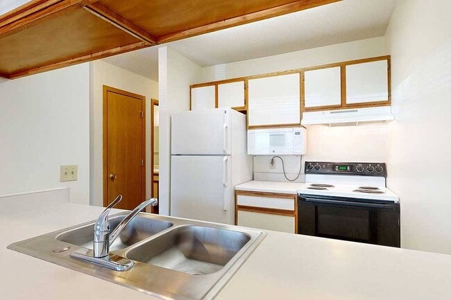 Whip up your favorite meals in our Bonsai studio, featuring a galley kitchen that keeps everything within reach. - Highland View Apartments