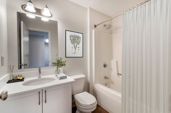 Renovated Package I bath with white laminate countertops, white cabinetry, and hard surface flooring - eaves Burlington