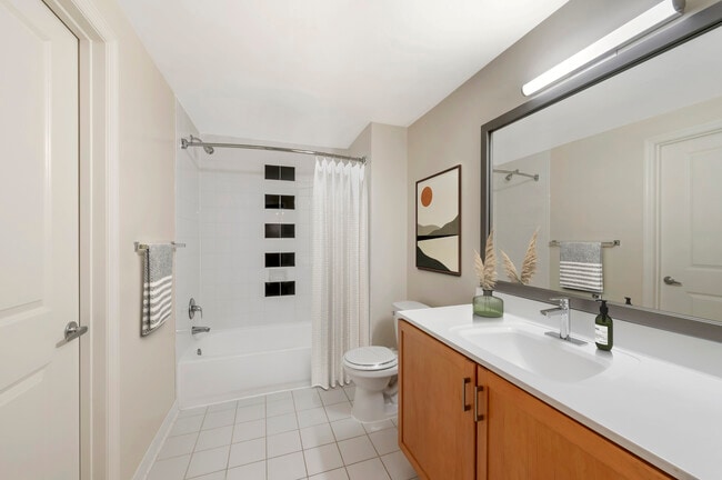 Updated Finishes bath with white laminate countertops, oak cabinetry, and hard surface flooring - Kanso Silver Spring