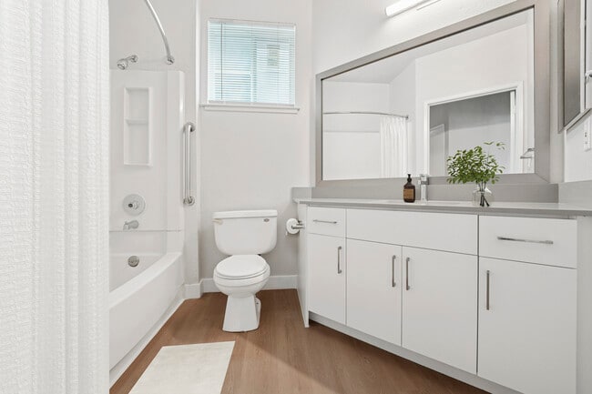 Renovated Package I bath with white cabinetry, grey quartz countertops, and hard surface flooring - Avalon Fremont