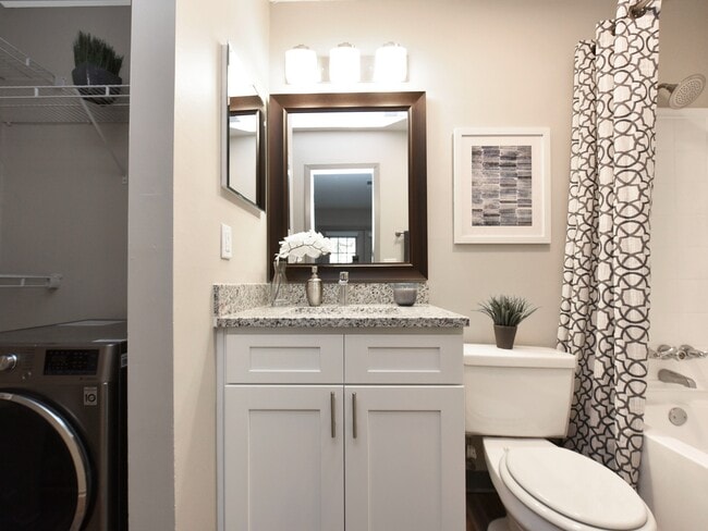 Bright bathroom with granite counters and bathtub - Copper Pointe