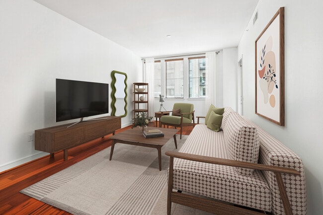 Experience the elegance of this chic living room, adorned with contemporary wooden furniture and abundant natural light. - Arrive River Oaks